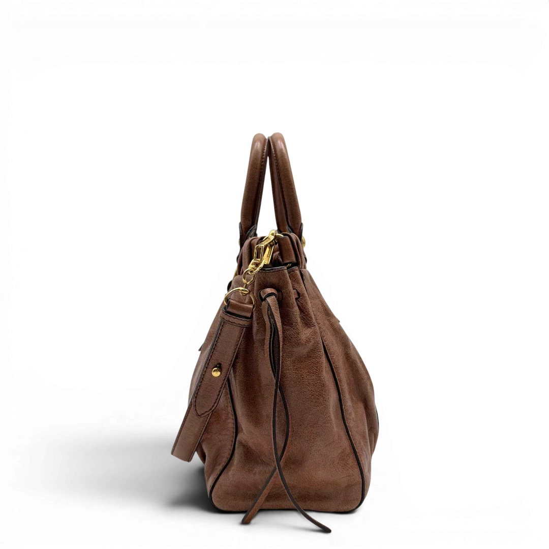 https://cdn.shopify.com/s/files/1/0564/9376/8855/files/Miu_Miu_Handtasche_Vitello_Lux_mit_Umhangegurt_aus_Leder_braun_vintage6494.webp?v=1778682434