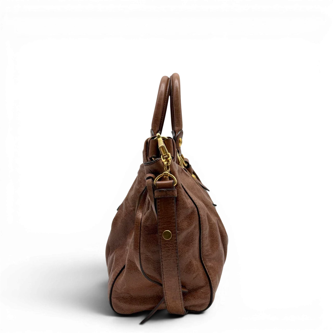 https://cdn.shopify.com/s/files/1/0564/9376/8855/files/Miu_Miu_Handtasche_Vitello_Lux_mit_Umhangegurt_aus_Leder_braun_vintage6495.webp?v=1778682434