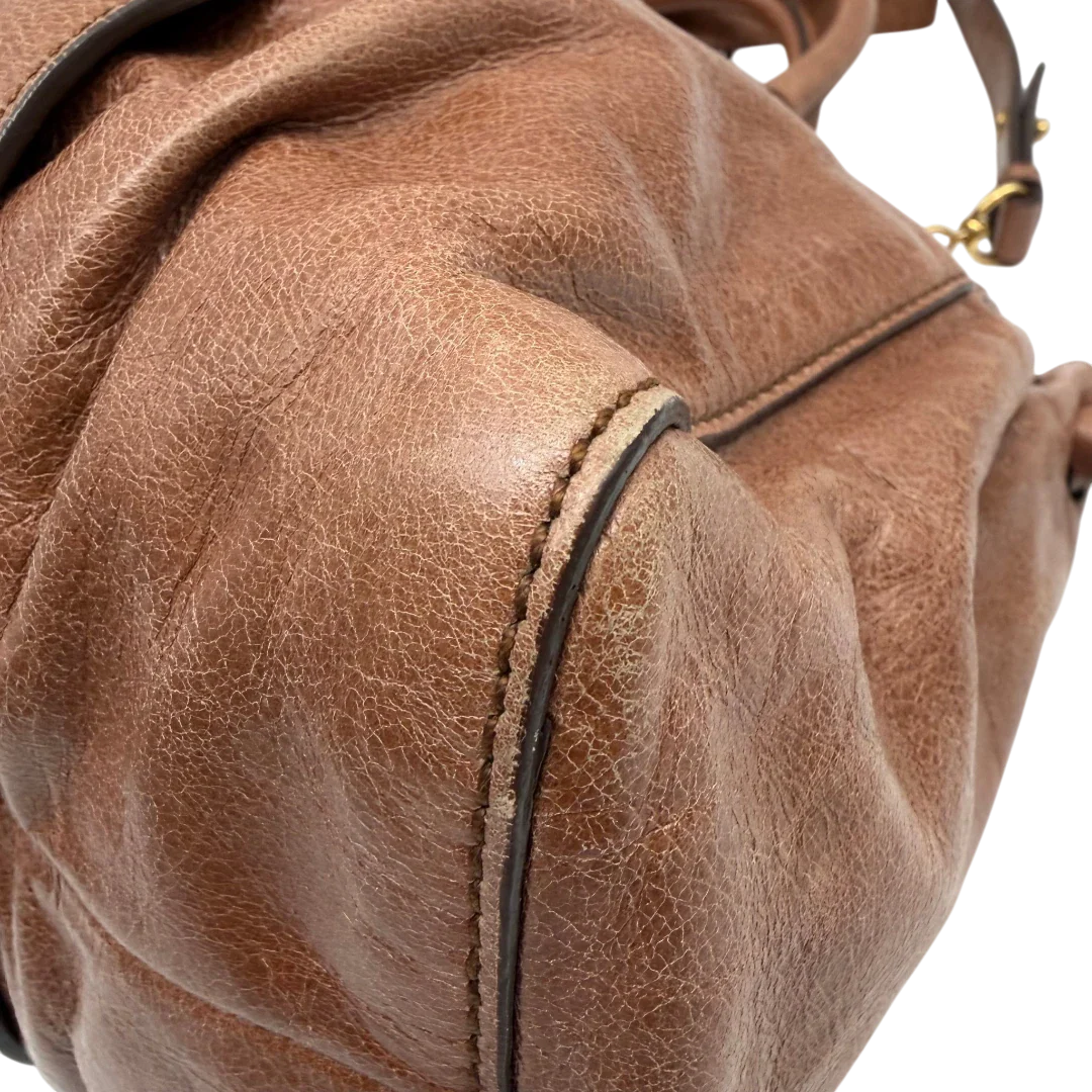 https://cdn.shopify.com/s/files/1/0564/9376/8855/files/Miu_Miu_Handtasche_Vitello_Lux_mit_Umhangegurt_aus_Leder_braun_vintage6497.webp?v=1778682434