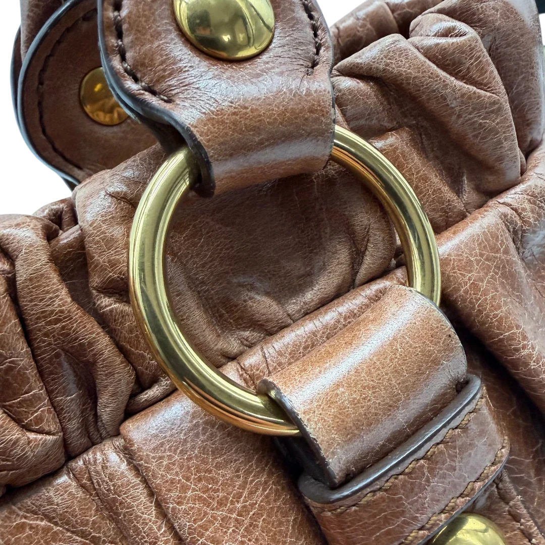 https://cdn.shopify.com/s/files/1/0564/9376/8855/files/Miu_Miu_Handtasche_Vitello_Lux_mit_Umhangegurt_aus_Leder_braun_vintage6504.webp?v=1778682434