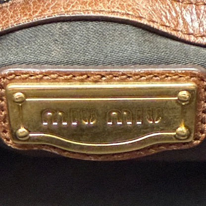 https://cdn.shopify.com/s/files/1/0564/9376/8855/files/Miu_Miu_Handtasche_Vitello_Lux_mit_Umhangegurt_aus_Leder_braun_vintage6507.webp?v=1778682434