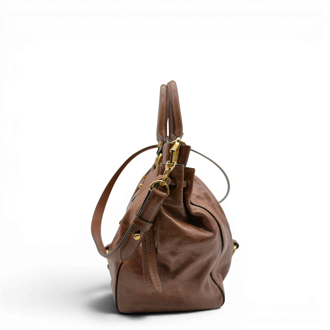 https://cdn.shopify.com/s/files/1/0564/9376/8855/files/Miu_Miu_Handtasche_Vitello_Lux_mit_Umhangegurt_aus_Leder_dunkelbraun_vintage7244.webp?v=1778681726