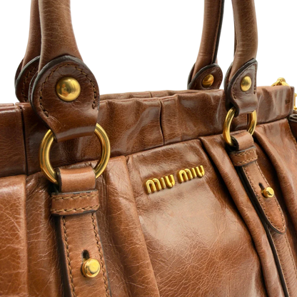 https://cdn.shopify.com/s/files/1/0564/9376/8855/files/Miu_Miu_Handtasche_Vitello_Lux_mit_Umhangegurt_aus_Leder_dunkelbraun_vintage7248.webp?v=1778681729