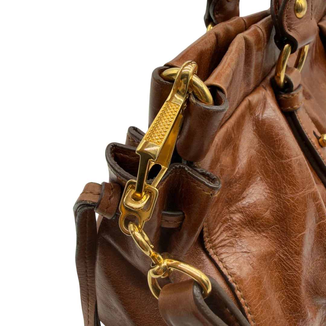 https://cdn.shopify.com/s/files/1/0564/9376/8855/files/Miu_Miu_Handtasche_Vitello_Lux_mit_Umhangegurt_aus_Leder_dunkelbraun_vintage7249.webp?v=1778681727