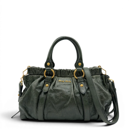 https://cdn.shopify.com/s/files/1/0564/9376/8855/files/Miu_Miu_Handtasche_Vitello_Lux_mit_Umhangegurt_aus_Leder_dunkelgrun_vintage7442.webp?v=1779291830