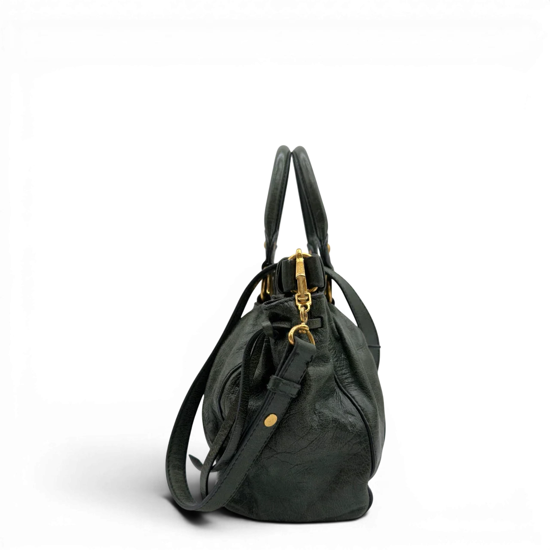 https://cdn.shopify.com/s/files/1/0564/9376/8855/files/Miu_Miu_Handtasche_Vitello_Lux_mit_Umhangegurt_aus_Leder_dunkelgrun_vintage7445.webp?v=1779291830