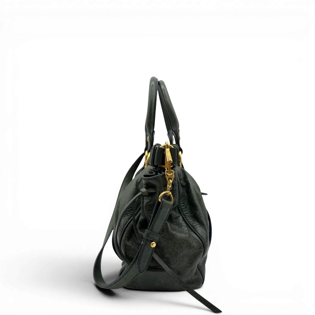 https://cdn.shopify.com/s/files/1/0564/9376/8855/files/Miu_Miu_Handtasche_Vitello_Lux_mit_Umhangegurt_aus_Leder_dunkelgrun_vintage7446.webp?v=1779291830