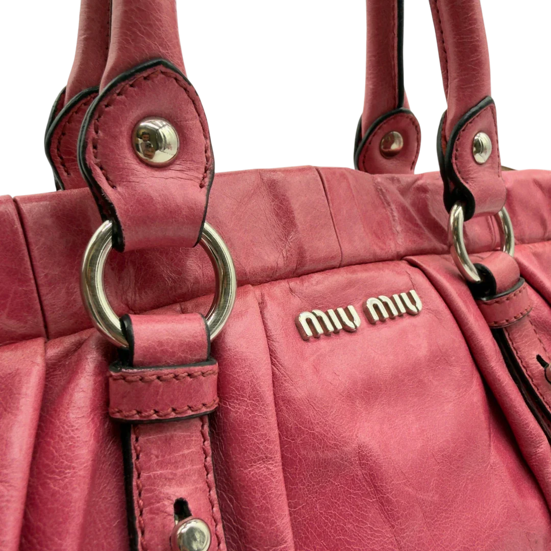 https://cdn.shopify.com/s/files/1/0564/9376/8855/files/Miu_Miu_Handtasche_Vitello_Lux_mit_Umhangegurt_aus_Leder_pink_vintage7956.webp?v=1779965633