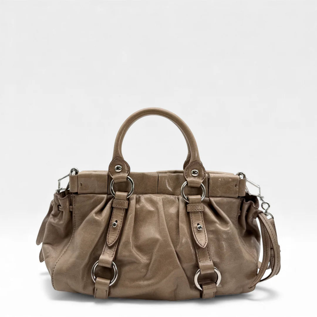 https://cdn.shopify.com/s/files/1/0564/9376/8855/files/Miu_Miu_Handtasche_Vitello_Lux_small_aus_Leder_beige_vintage_5358.webp?v=1765402566