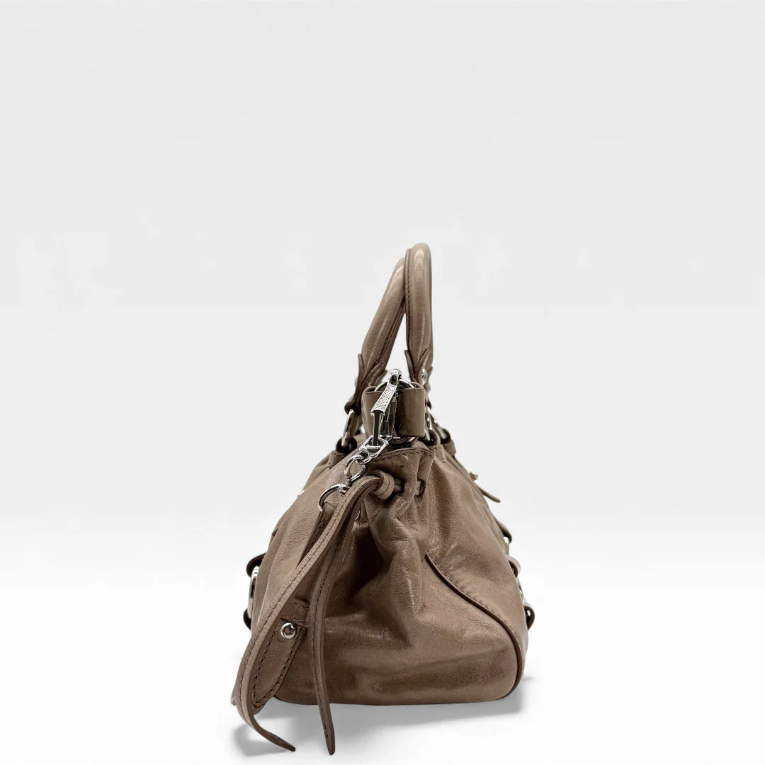 https://cdn.shopify.com/s/files/1/0564/9376/8855/files/Miu_Miu_Handtasche_Vitello_Lux_small_aus_Leder_beige_vintage_5360.webp?v=1765402566