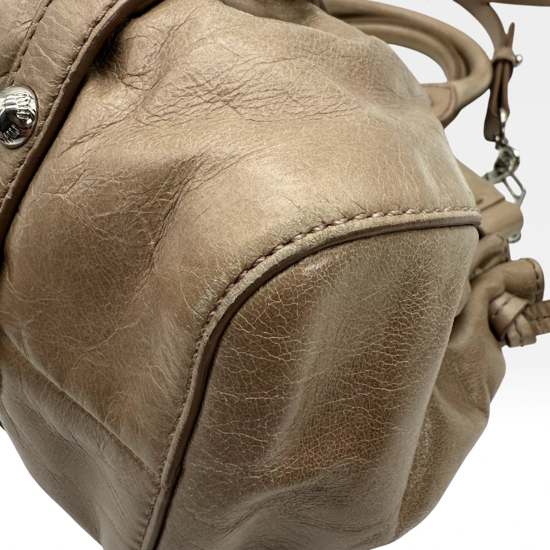 https://cdn.shopify.com/s/files/1/0564/9376/8855/files/Miu_Miu_Handtasche_Vitello_Lux_small_aus_Leder_beige_vintage_5364.webp?v=1765402566