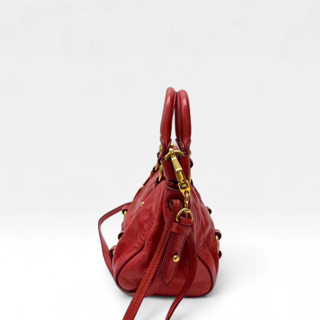 https://cdn.shopify.com/s/files/1/0564/9376/8855/files/Miu_Miu_Handtasche_Vitello_Lux_small_aus_Leder_rot_vintage_handbag4816.webp?v=1760695520