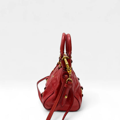https://cdn.shopify.com/s/files/1/0564/9376/8855/files/Miu_Miu_Handtasche_Vitello_Lux_small_aus_Leder_rot_vintage_handbag4816.webp?v=1760695520