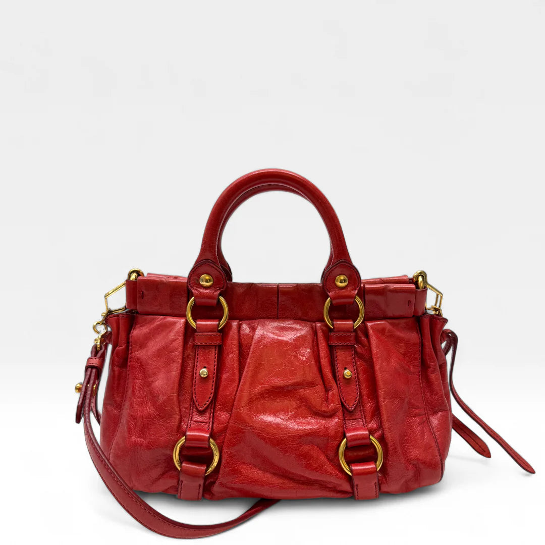 https://cdn.shopify.com/s/files/1/0564/9376/8855/files/Miu_Miu_Handtasche_Vitello_Lux_small_aus_Leder_rot_vintage_handbag4818.webp?v=1760695520