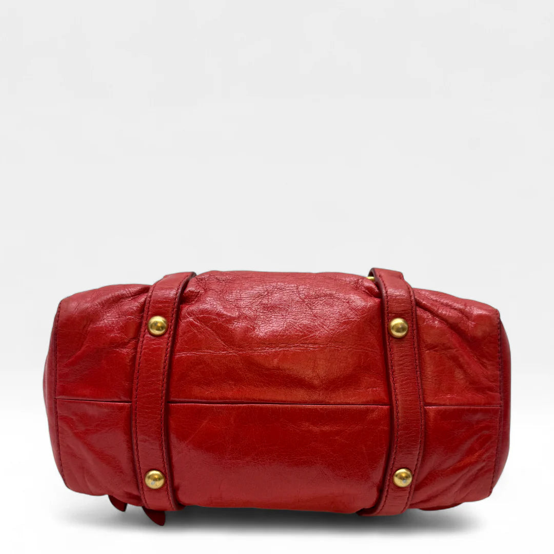 https://cdn.shopify.com/s/files/1/0564/9376/8855/files/Miu_Miu_Handtasche_Vitello_Lux_small_aus_Leder_rot_vintage_handbag4819.webp?v=1760695505