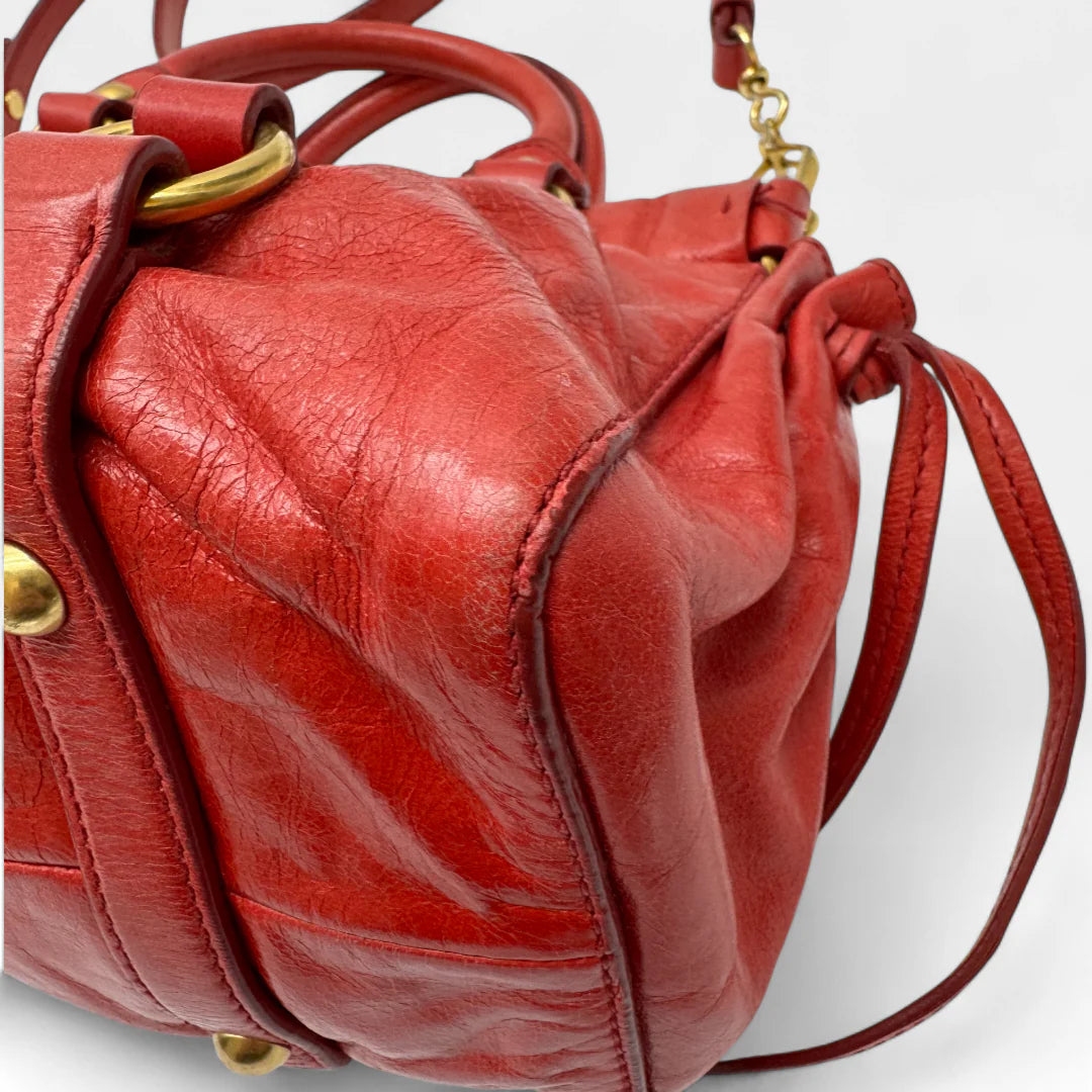 https://cdn.shopify.com/s/files/1/0564/9376/8855/files/Miu_Miu_Handtasche_Vitello_Lux_small_aus_Leder_rot_vintage_handbag4821.webp?v=1760695505