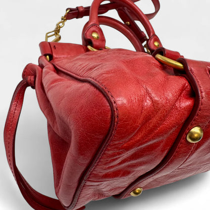 https://cdn.shopify.com/s/files/1/0564/9376/8855/files/Miu_Miu_Handtasche_Vitello_Lux_small_aus_Leder_rot_vintage_handbag4822.webp?v=1760695505
