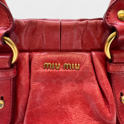https://cdn.shopify.com/s/files/1/0564/9376/8855/files/Miu_Miu_Handtasche_Vitello_Lux_small_aus_Leder_rot_vintage_handbag4825.webp?v=1760695505