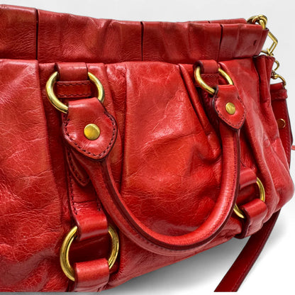 https://cdn.shopify.com/s/files/1/0564/9376/8855/files/Miu_Miu_Handtasche_Vitello_Lux_small_aus_Leder_rot_vintage_handbag4827.webp?v=1760695505