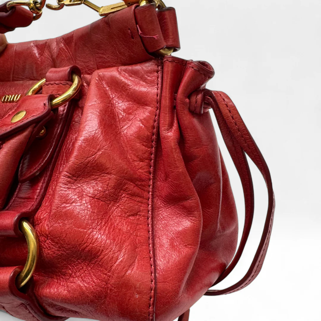https://cdn.shopify.com/s/files/1/0564/9376/8855/files/Miu_Miu_Handtasche_Vitello_Lux_small_aus_Leder_rot_vintage_handbag4828.webp?v=1760695505