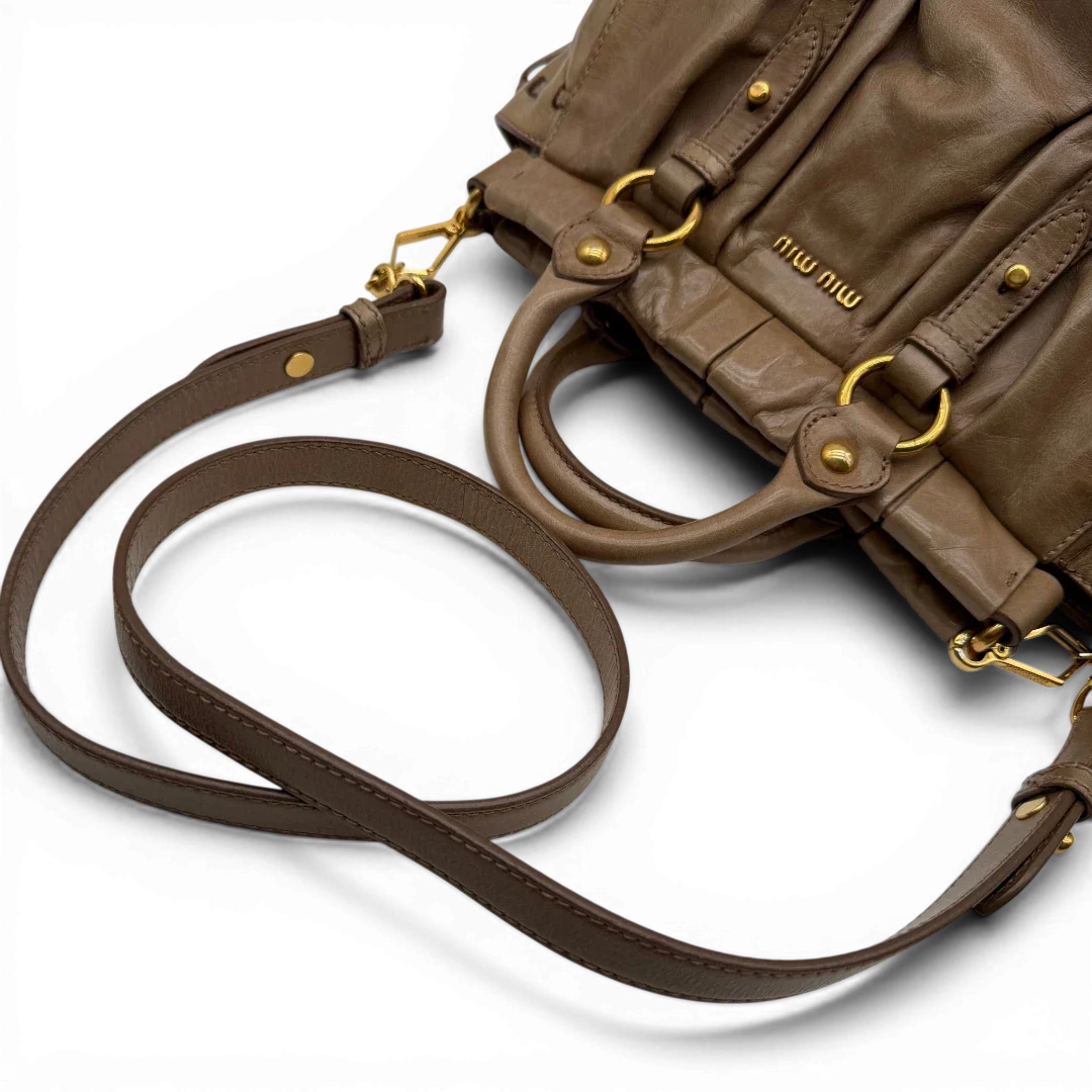 https://cdn.shopify.com/s/files/1/0564/9376/8855/files/Miu_Miu_Handtasche_Vitello_Lux_small_mit_Umhangegurt_aus_Leder_beige_vintage3407.webp?v=1774390718