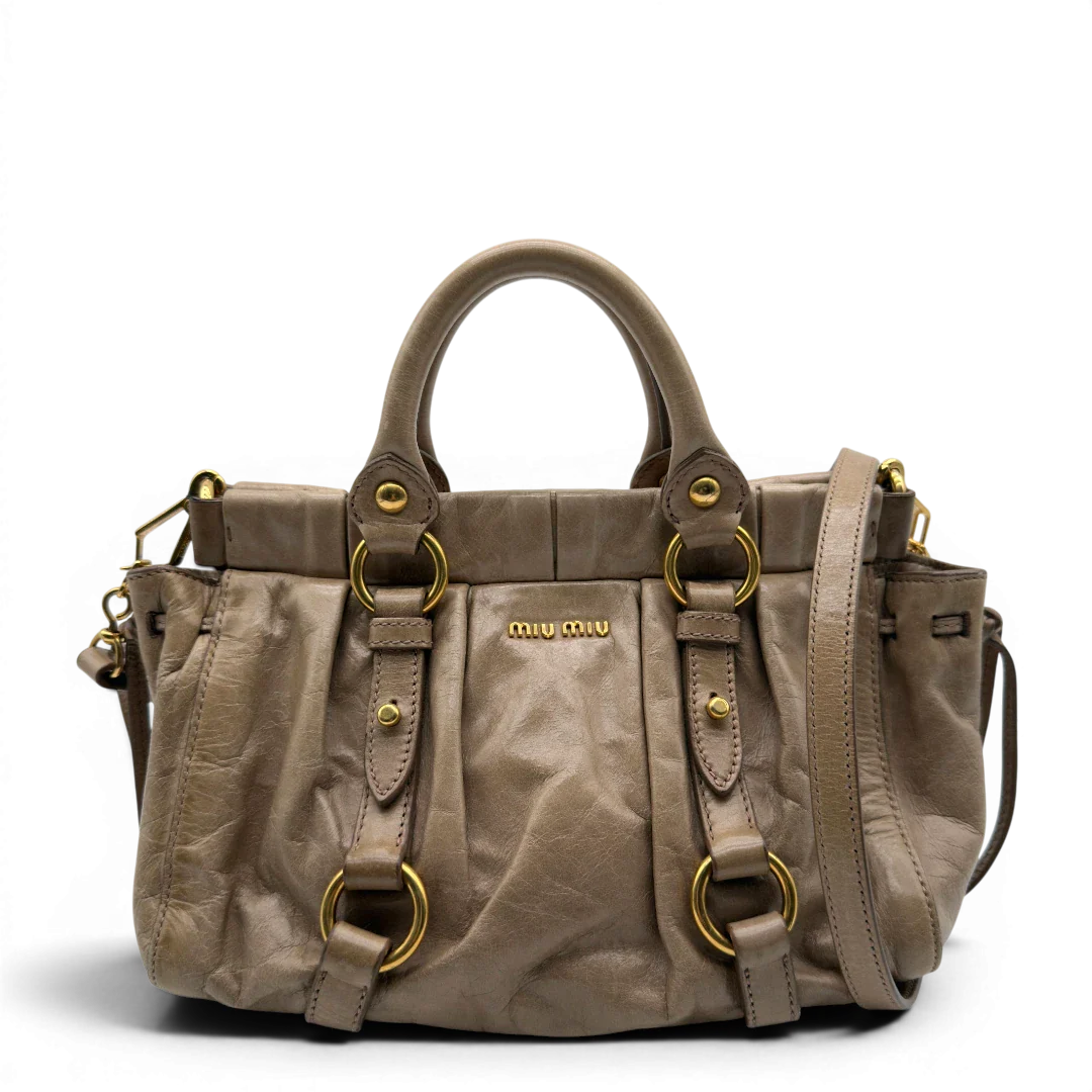 https://cdn.shopify.com/s/files/1/0564/9376/8855/files/Miu_Miu_Handtasche_Vitello_Lux_small_mit_Umhangegurt_aus_Leder_beige_vintage7404.webp?v=1778679864