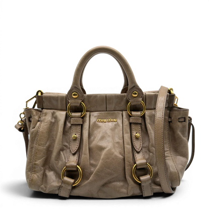 https://cdn.shopify.com/s/files/1/0564/9376/8855/files/Miu_Miu_Handtasche_Vitello_Lux_small_mit_Umhangegurt_aus_Leder_beige_vintage7404.webp?v=1778679864
