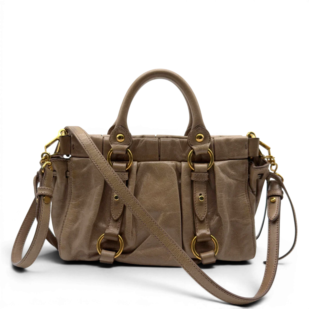 https://cdn.shopify.com/s/files/1/0564/9376/8855/files/Miu_Miu_Handtasche_Vitello_Lux_small_mit_Umhangegurt_aus_Leder_beige_vintage7405.webp?v=1778679863