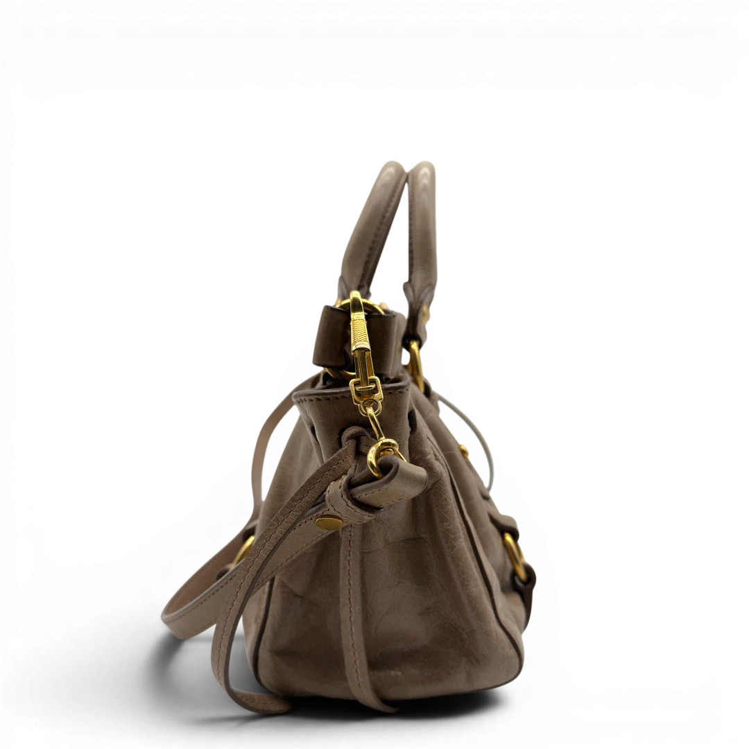 https://cdn.shopify.com/s/files/1/0564/9376/8855/files/Miu_Miu_Handtasche_Vitello_Lux_small_mit_Umhangegurt_aus_Leder_beige_vintage7407.webp?v=1778679863