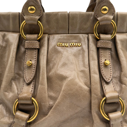 https://cdn.shopify.com/s/files/1/0564/9376/8855/files/Miu_Miu_Handtasche_Vitello_Lux_small_mit_Umhangegurt_aus_Leder_beige_vintage7415.webp?v=1778679864