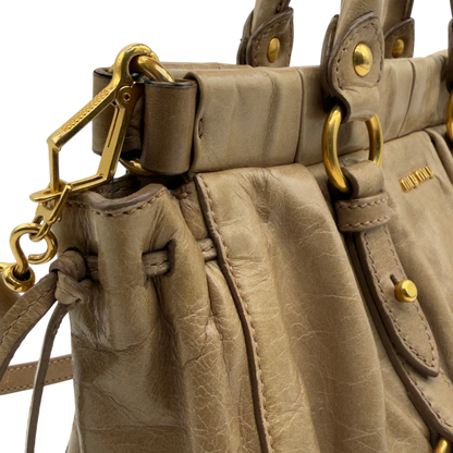 https://cdn.shopify.com/s/files/1/0564/9376/8855/files/Miu_Miu_Handtasche_Vitello_Lux_small_mit_Umhangegurt_aus_Leder_beige_vintage7416.webp?v=1778679864