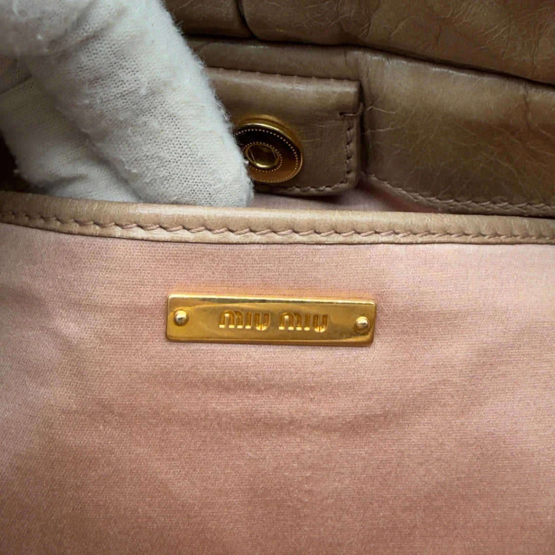 https://cdn.shopify.com/s/files/1/0564/9376/8855/files/Miu_Miu_Handtasche_Vitello_Lux_small_mit_Umhangegurt_aus_Leder_beige_vintage7418.webp?v=1778679864