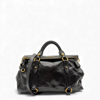 https://cdn.shopify.com/s/files/1/0564/9376/8855/files/Miu_Miu_Handtasche_Vitello_Satchel_aus_Leder_schwarz_vintage_handbag3060.webp?v=1764855368