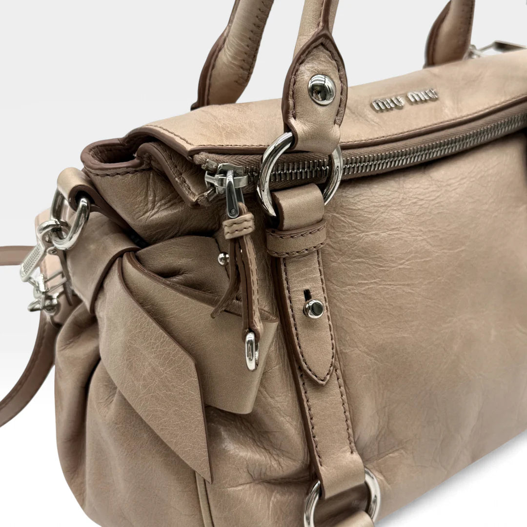 https://cdn.shopify.com/s/files/1/0564/9376/8855/files/Miu_Miu_Handtasche_Vitello_Satchel_small_aus_Leder_beige_vintage_handbag2753.webp?v=1762427795