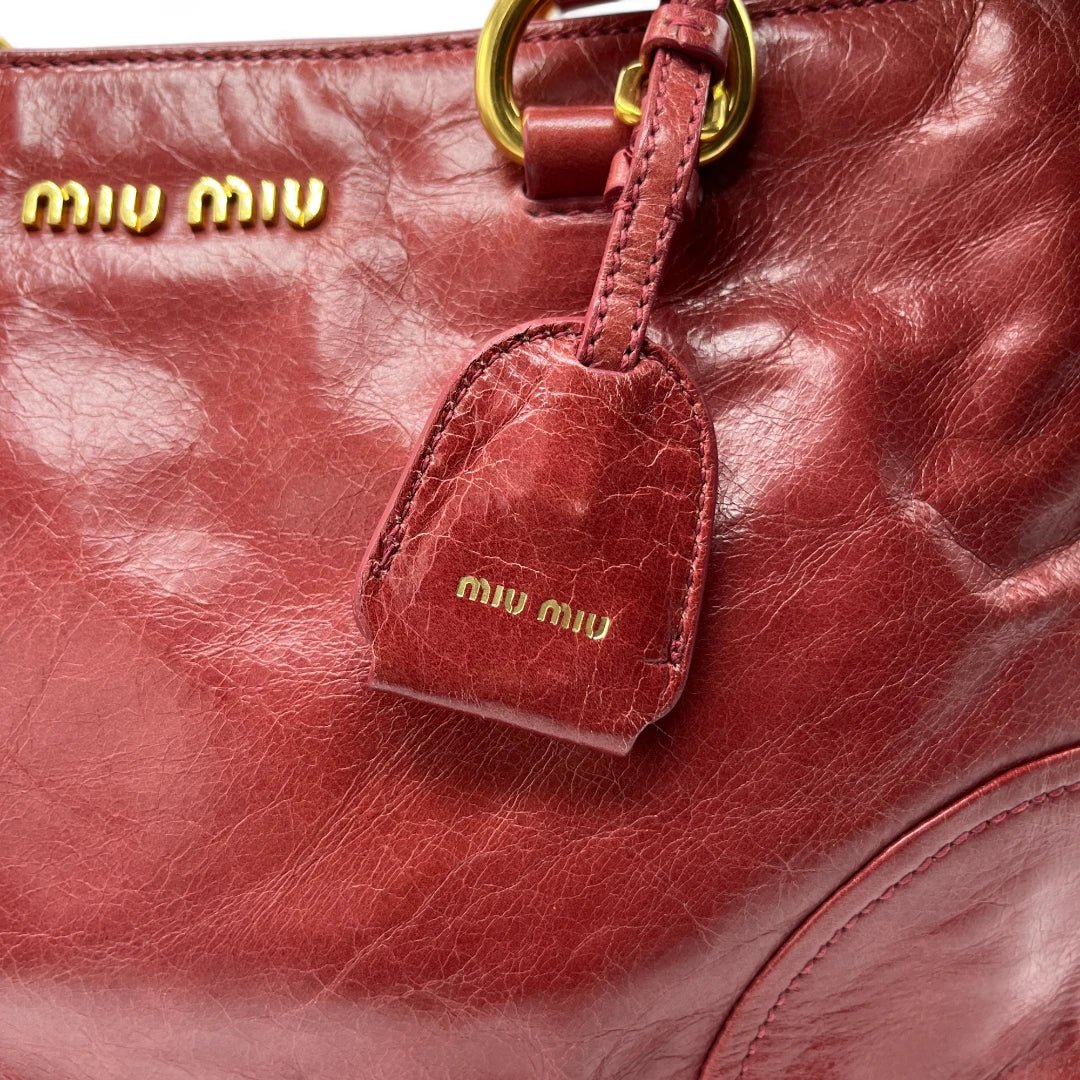https://cdn.shopify.com/s/files/1/0564/9376/8855/files/Miu_Miu_Handtasche_Vitello_Shine_mit_Umhaengegurt_aus_Leder_rot_Vintage_Designer_Y2K_Handbag_8811.webp?v=1741765538