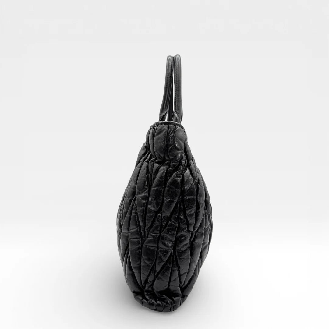https://cdn.shopify.com/s/files/1/0564/9376/8855/files/Miu_Miu_Shopper_Matelasse_aus_Leder_schwarz_vintage_88283.webp?v=1769119101