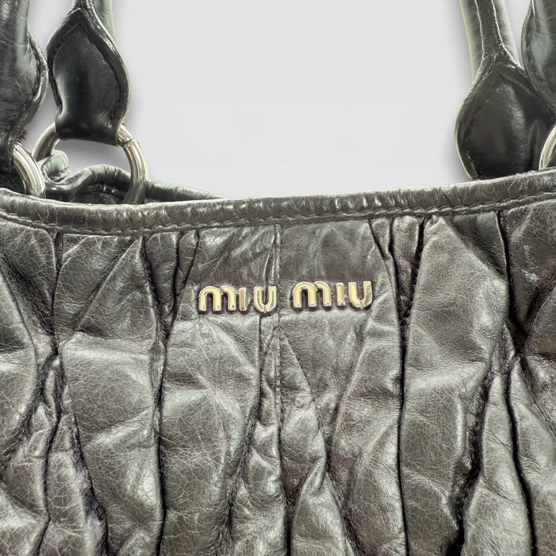 https://cdn.shopify.com/s/files/1/0564/9376/8855/files/Miu_Miu_Shopper_Matelasse_aus_Leder_schwarz_vintage_88353.webp?v=1769119101