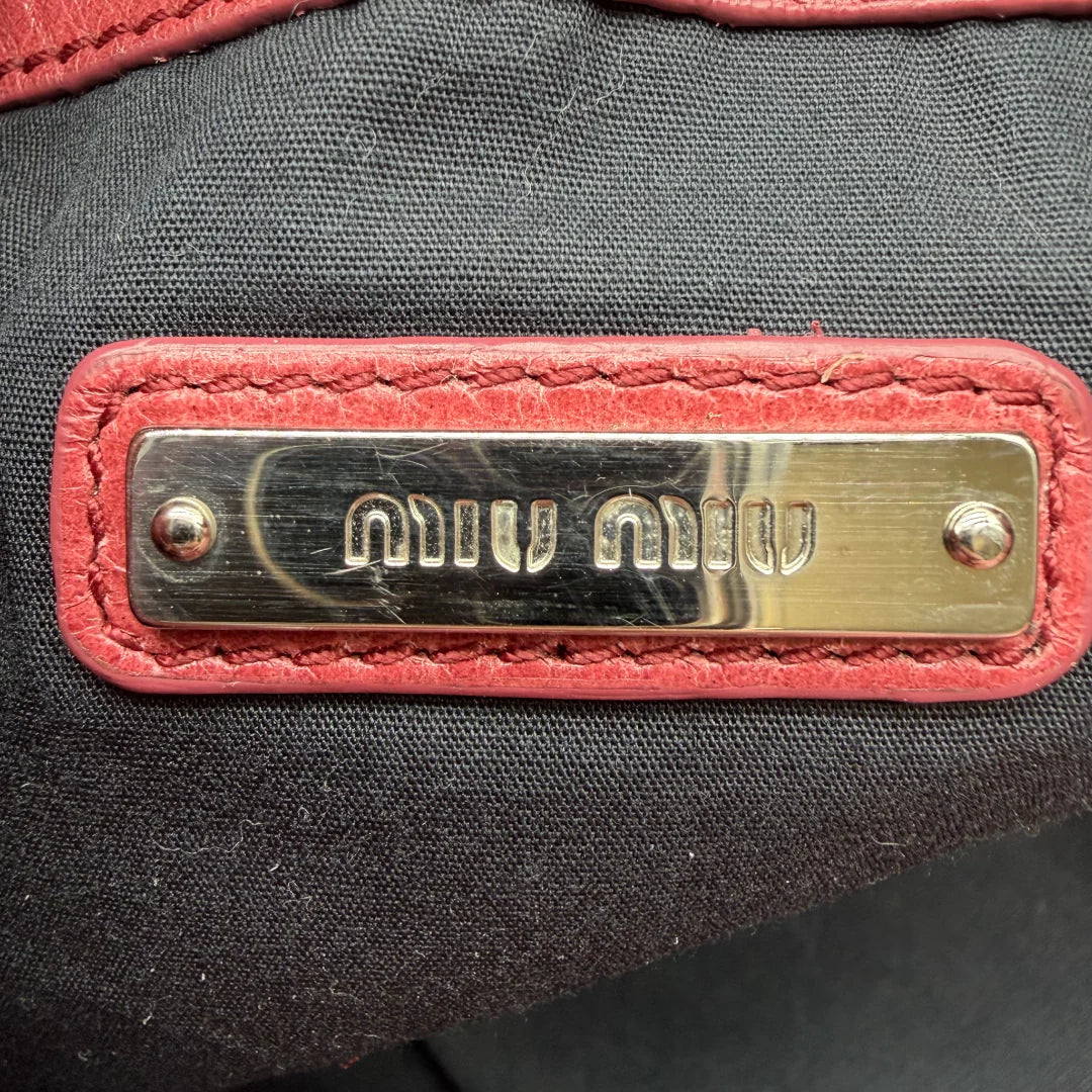 https://cdn.shopify.com/s/files/1/0564/9376/8855/files/Miu_Miu_Umhangetasche_Bucket_aus_Leder_rot_vintage_crossbody1986.webp?v=1764258063