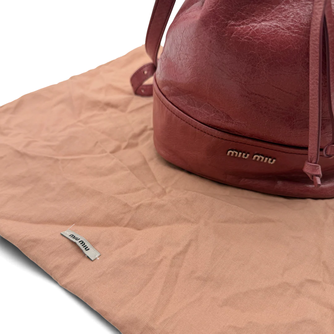 https://cdn.shopify.com/s/files/1/0564/9376/8855/files/Miu_Miu_Umhangetasche_Bucket_aus_Leder_rot_vintage_crossbody1993.webp?v=1764258063
