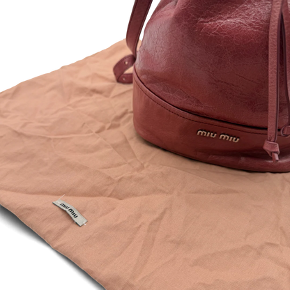https://cdn.shopify.com/s/files/1/0564/9376/8855/files/Miu_Miu_Umhangetasche_Bucket_aus_Leder_rot_vintage_crossbody1993.webp?v=1764258063