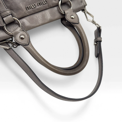 https://cdn.shopify.com/s/files/1/0564/9376/8855/files/Miu_Miu_Vitello_leather_crossbody_gray_second_hand_Y2K_designer_handbag_1578.webp?v=1743081520