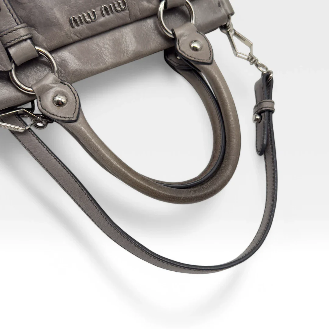 https://cdn.shopify.com/s/files/1/0564/9376/8855/files/Miu_Miu_Vitello_leather_crossbody_gray_second_hand_Y2K_designer_handbag_1578.webp?v=1743081520