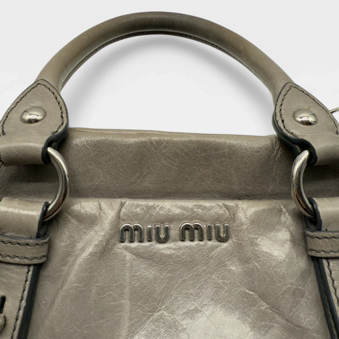 https://cdn.shopify.com/s/files/1/0564/9376/8855/files/Miu_Miu_Vitello_leather_crossbody_gray_second_hand_Y2K_designer_handbag_1579.webp?v=1743081519