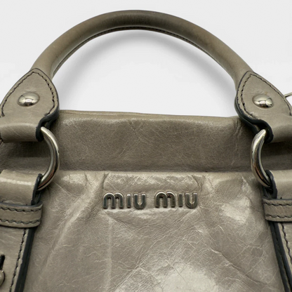 https://cdn.shopify.com/s/files/1/0564/9376/8855/files/Miu_Miu_Vitello_leather_crossbody_gray_second_hand_Y2K_designer_handbag_1579.webp?v=1743081519