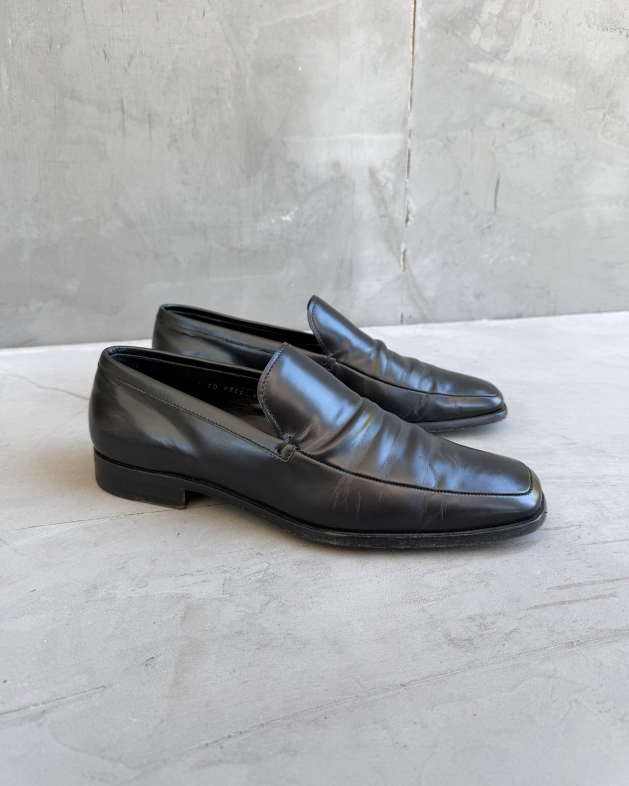 Prada Black Leather Loafers – UK 8.5-on a concrete background