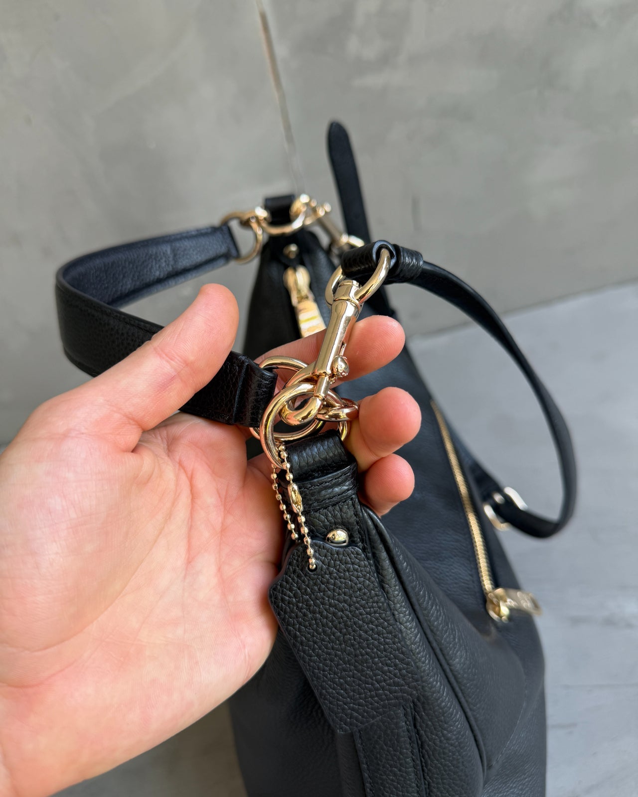 Coach Black Leather Shoulder Bag with Crossbody Strap-on a concrete background