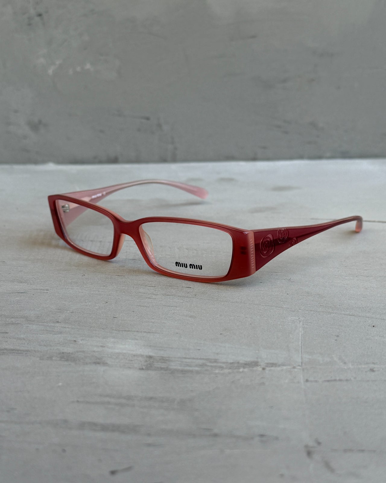 Miu Miu Pink Clear Lens Glasses-on a concrete background