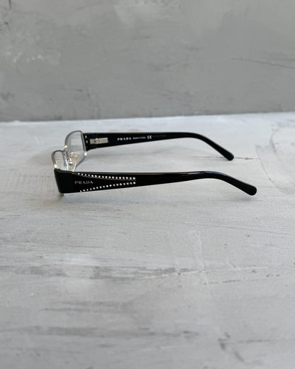 Prada Clear Lens Silver Frame Glasses-on a concrete background
