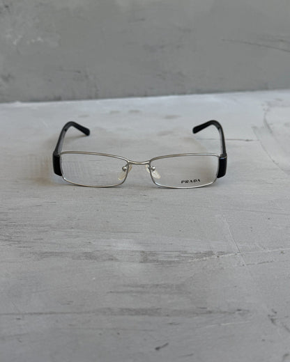 Prada Clear Lens Silver Frame Glasses-on a concrete background