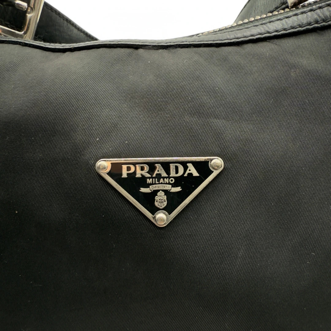 https://cdn.shopify.com/s/files/1/0564/9376/8855/files/Prada_Handtasche_Halbmond_Form_schwarze_Lederecken_Nylon_schwarz_vintage_designer_handbag_4207.webp?v=1741796308